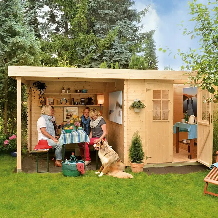 Kiehnholz Gartenhaus Eco-Lounge - Außenmaß inkl. Dachüberstand (B x T): 454 x 230 cm, Holz, Natur - Ein helles Holzgartenhaus mit offenem Bereich, in dem Personen sitzen und ein Hund liegt im Gras. Der Gartenhaus bietet zusätzlichen Raum im Freien.
