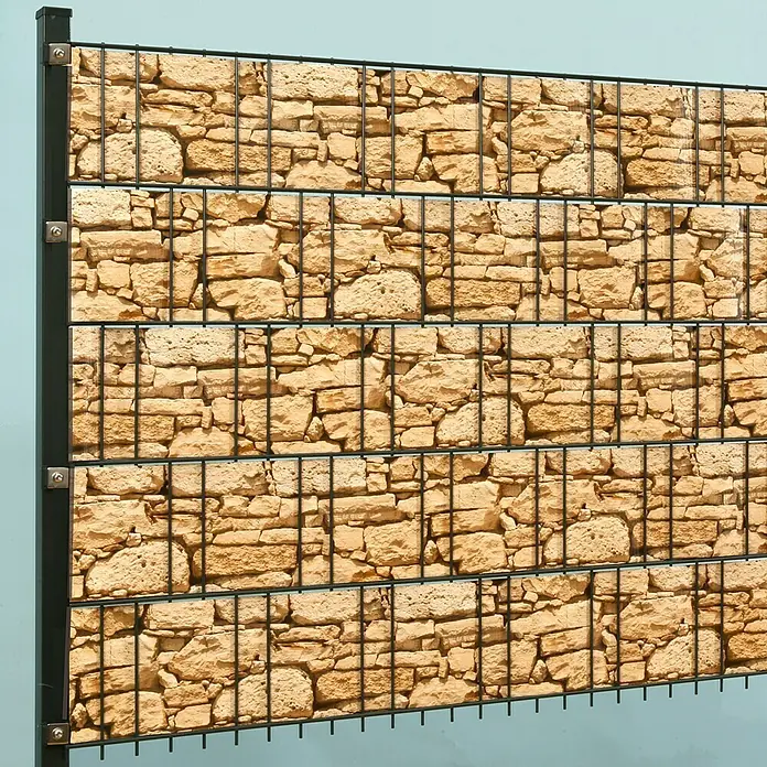 Stabilit Sichtschutzstreifen - Sandstein, 2.050 x 19 cm - Ein Gabionenzaun mit Steinmuster im Hintergrund, der eine rustikale und dennoch moderne Optik bietet. Ideal als Sichtschutz oder zur Gartengestaltung.
