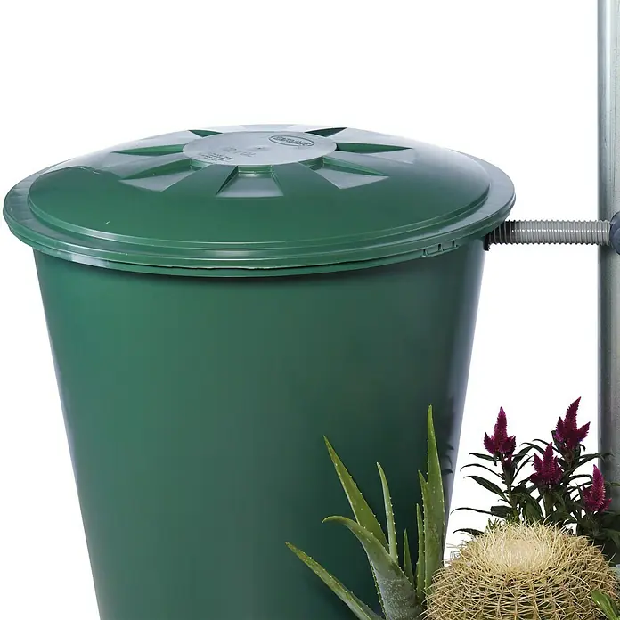 Garantia Regensammler Rapido - Geeignet für: Fallrohrgrößen DN 70 - 100 - Ein grüner Regenspeicher mit Deckel und Anschluss für die Gartenbewässerung, umgeben von Sukkulenten. Praktisch und umweltschonend!