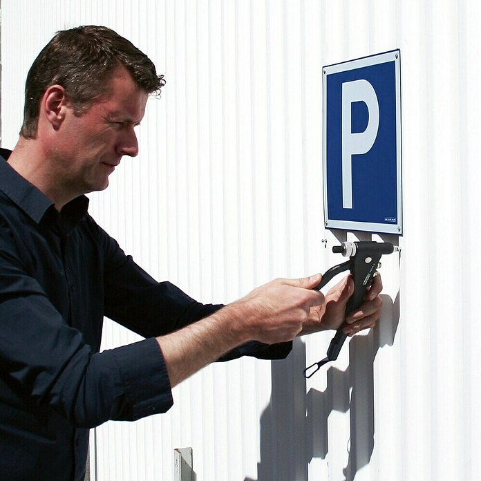 Worker installing a blue parking sign