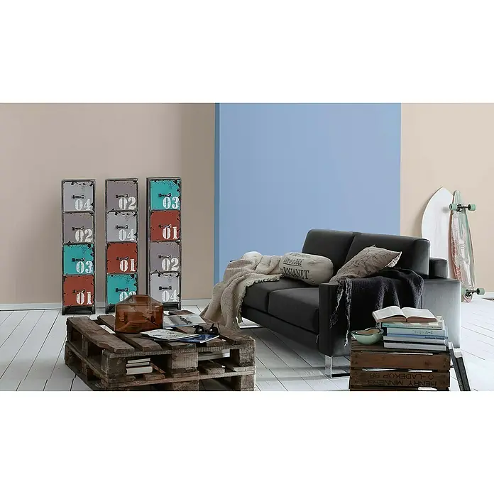 A.S. Création Vliestapete Glatte Wand Meistervlies 5 - Cappuccino, Uni, 10,05 x 0,53 m - Einrichtungsidee mit einem schwarzen Sofa, einem Couchtisch aus Paletten und bunten Regalen.