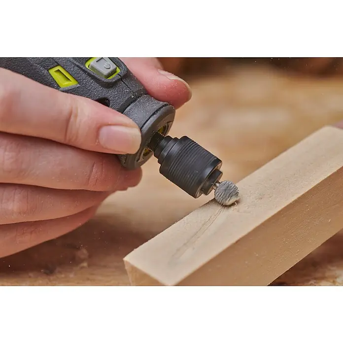 Ryobi Fräser RAR704 - Arbeitsdurchmesser: 9 mm - Nahaufnahme eines rotierenden Werkzeugs, das Holz bearbeitet, wobei die Präzision und die feinen Details des Schleifprozesses hervorgehoben werden.