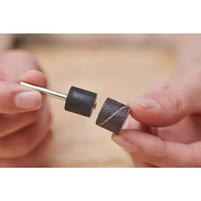 Ryobi Schleifdorn RAR606 - Durchmesser Schaft: 3,2 mm - Ein Schleifhülsen-Set für ein rotierendes Werkzeug wird von zwei Händen gehalten.