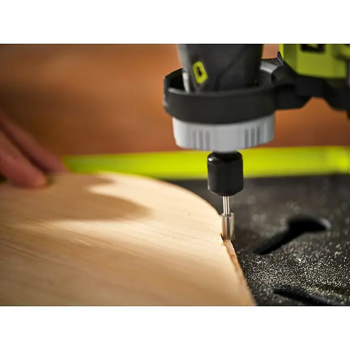 Ryobi Fräser RAR308 gerade - Arbeitsdurchmesser: 6,35 mm, Passend für: Rotationswerkzeuge mit 3,2 mm (1/8") Spannzangenkapazität - Nahaufnahme einer Oberfräse, die ein Holzstück bearbeitet. Perfekt für präzise Holzarbeiten und DIY-Projekte mit sauberem Schnitt.