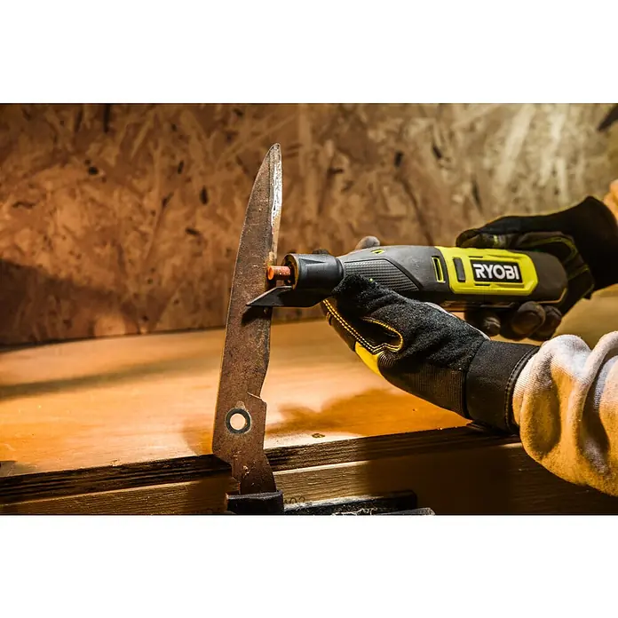 Ryobi Schleifstein-Set RAR52-3 - 3 -tlg. - Eine Person benutzt ein gelbes Ryobi-Elektrowerkzeug, um ein Metallstück zu schleifen. Das Werkzeug ist kompakt und kabellos.