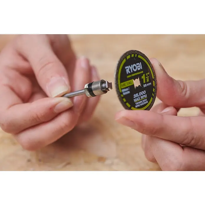Ryobi Aufspanndorn "Twist Look" RAR902Arbeitsdurchmesser: 3,2 mm - Eine Person hält einen Ryobi Hochleistungs-Trennschleifer aus Metall, 1 1/2 Zoll Durchmesser und 38 mm, mit maximal 35.000 U/min.