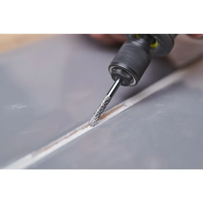 Ryobi Fugenfräser RAR307 - Arbeitsdurchmesser: 3,2 mm, Passend für: Rotationswerkzeuge mit 3,2 mm (1/8") Spannzangenkapazität - Ein Werkzeug fräst eine Nut in ein graues Material, ideal für Handwerker und Heimwerker, die präzise Arbeiten ausführen.