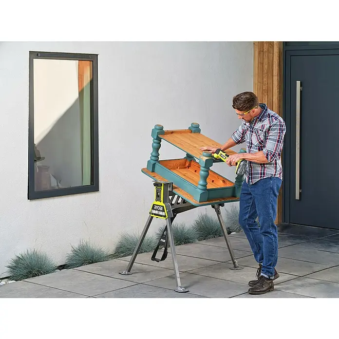 Ryobi ONE+HP Akku-Multifunktionswerkzeug RMT18X-0 - 18 V, Ohne Akku - Mann schleift mit einem Ryobi-Elektrowerkzeug einen Tisch im Freien, der auf einer Werkbank steht, um ihn zu restaurieren. Perfekt für DIY-Projekte!