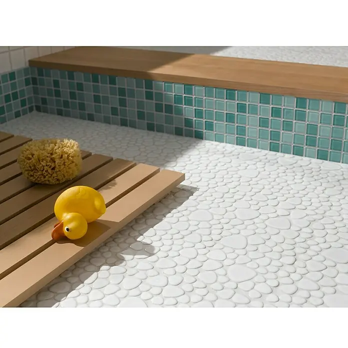 Mosaikfliese Quadrat Crystal Mix CM 4114 - 32,7 x 30,2 cm, Grün, Glänzend - Ein Badezimmer mit einer Badematte aus Holz, einem Badeschwamm und einer gelben Gummiente auf einem weißen Kieselboden.