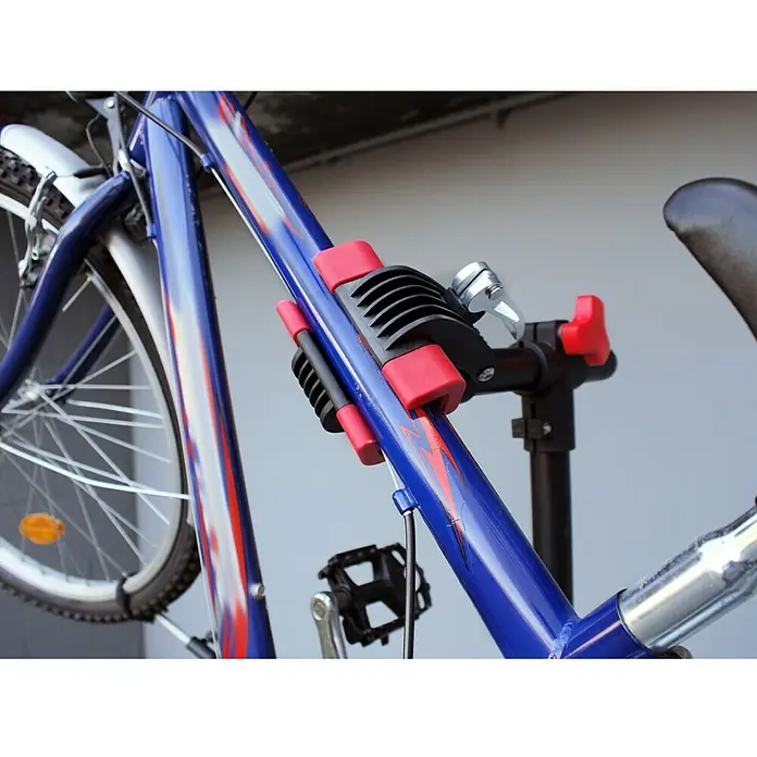 Eufab Fahrradmontageständer PROFI - Geeignet für: Rahmenstärke 2,5 - 4 cm, Nutzlast: 30 kg - Nahaufnahme eines blauen Fahrrads, das mit einer roten und schwarzen Fahrradreparaturklemme an einem Montageständer befestigt ist.