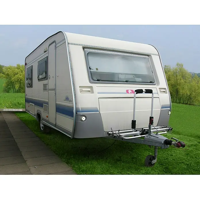 LAS Deichsel-Fahrradträger - Geeignet für: 2 Fahrräder, Max. Ladegewicht: 35 kg - Bild eines Hobby Wohnwagen mit Fahrradträger auf einer grünen Wiese, ideal für Familienausflüge und Camping.