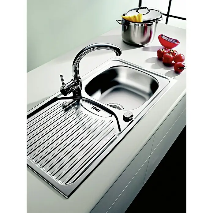 Admiral Fregadero encastrable ET 78 - 78 x 43,5 cm, Acero inoxidable, Liso - Fregadero con escurridor, grifo, olla con espaguetis, tomates y un utensilio de cocina rojo sobre una encimera blanca.