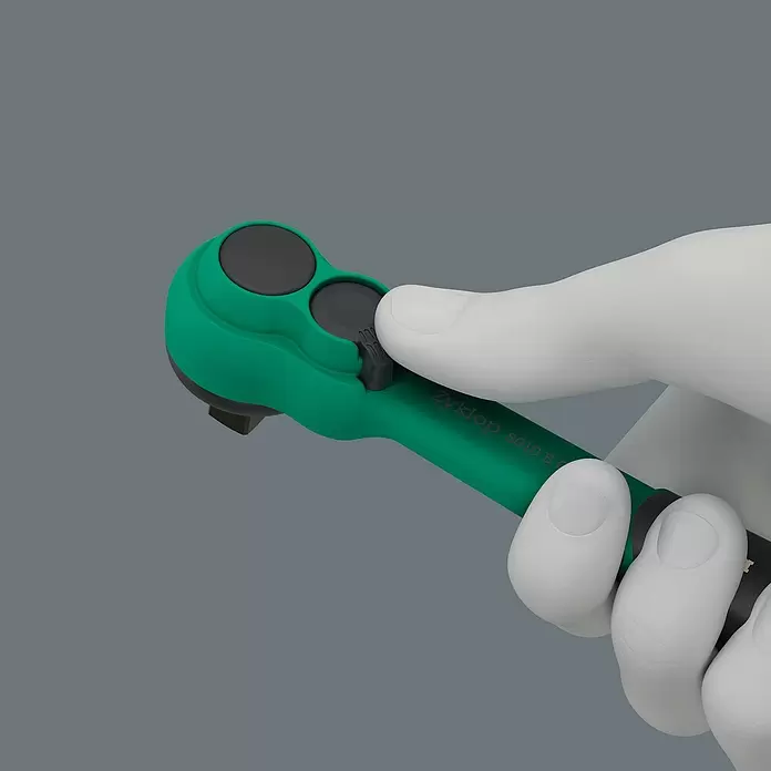 Wera Zyklop Steckschlüssel-Set Comfort - 16 -tlg., Antriebsgröße: ⅜″ - Eine weiße Hand hält eine grün-schwarze Wera Zyklop 8010 B Ratsche, ein Daumen drückt den Kopfmechanismus.