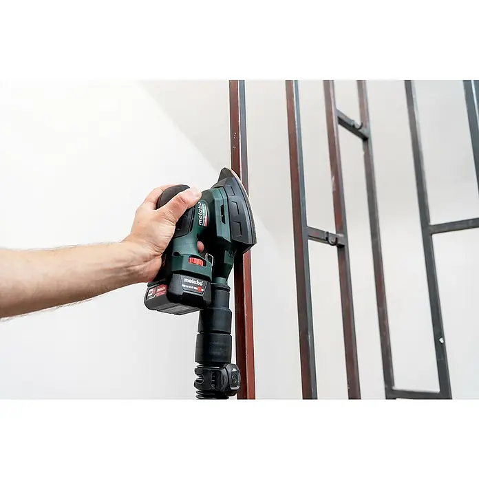 Metabo Akku-Multischleifer PowerMaxx SMA 12 BL - 12 V, Ohne Akku, Breite Schleifplatte: 100 mm, Länge Schleifplatte: 150 mm - Ein Mann benutzt einen Metabo-Schleifer, um Metall zu bearbeiten. Das Werkzeug ist kabellos und mit einem Akku ausgestattet.