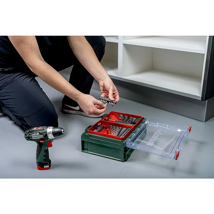 Metabo Akku-Bohrschrauber-Set PowerMaxx BS Basic - 12 V, 2 Akkus, 2 Ah, 34 Nm, 41 -tlg. - Nahaufnahme eines Mannes, der Schrauberbits aus einem Werkzeugkasten von Weidmüller entnimmt.
