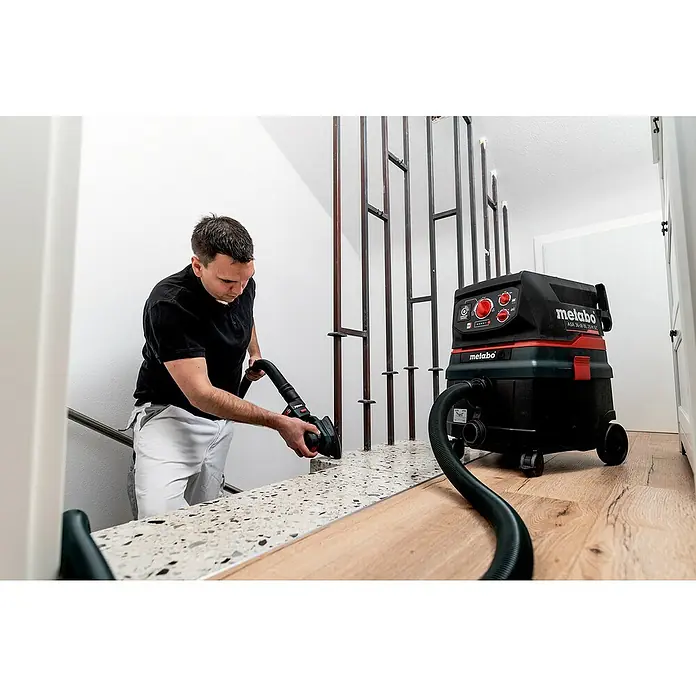 Metabo Akku-Multischleifer PowerMaxx SMA 12 BL - 12 V, Ohne Akku, Breite Schleifplatte: 100 mm, Länge Schleifplatte: 150 mm - Mann schleift Treppe mit Metabo Werkzeug, Metabo Staubsauger steht bereit. Präzision und Sauberkeit vereint in einem Arbeitsgang.