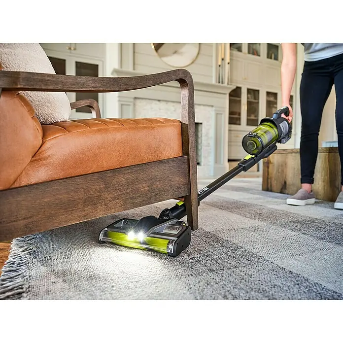 Ryobi ONE+ Akku-Staubsauger RASV18BL-0 - 18 V, Ohne Akku, Behältervolumen: 1.000 ml - Der Ryobi Akku-Staubsauger im Einsatz unter einem Sofa, der mit hellen LED-Leuchten ausgestattet ist, um die Reinigung zu erleichtern.