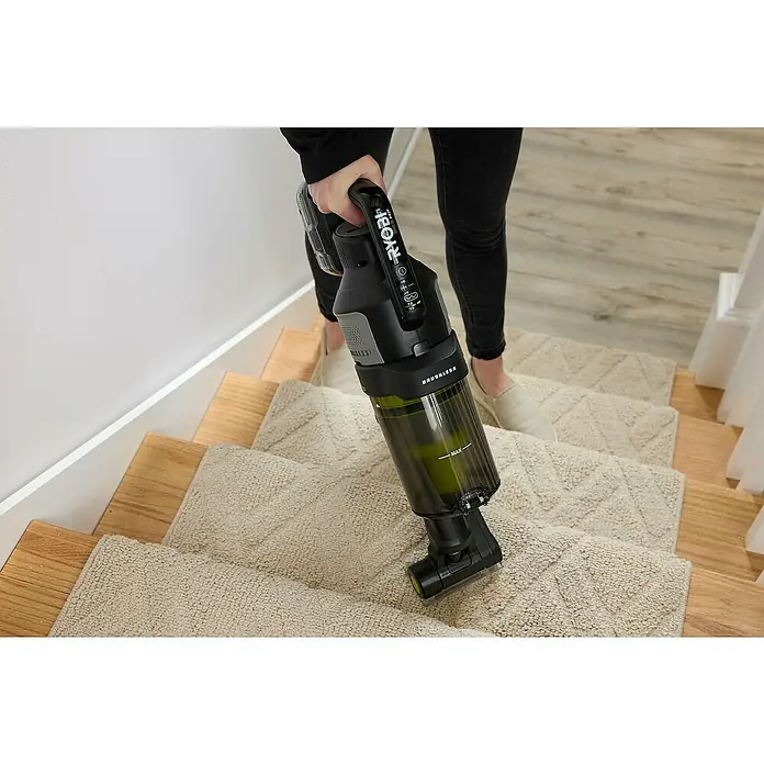 Ryobi ONE+ Akku-Staubsauger RASV18BL-0 - 18 V, Ohne Akku, Behältervolumen: 1.000 ml - Eine Person benutzt einen Ryobi Akku-Staubsauger, um eine Treppe mit Teppichstufen zu reinigen.