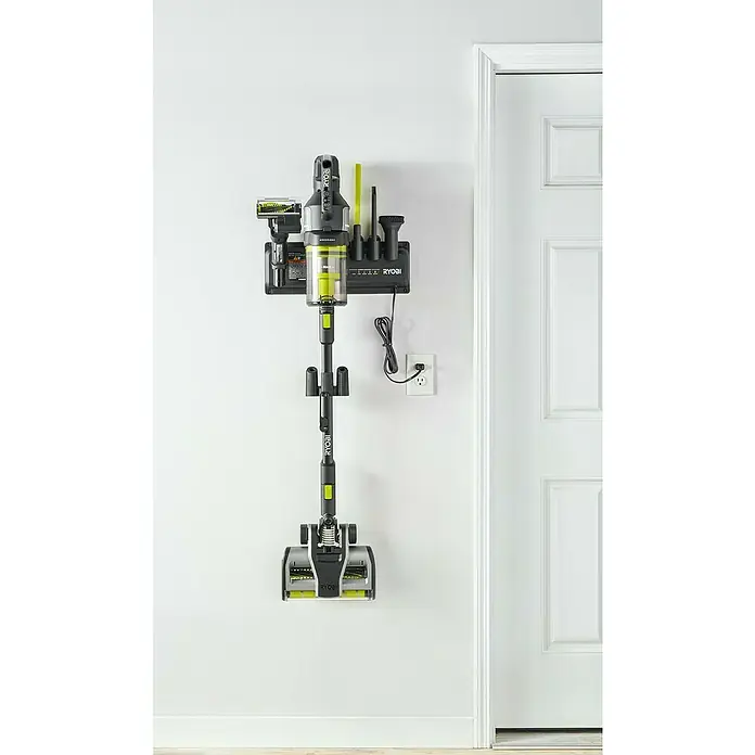 Ryobi ONE+ Wandhalterung mit Ladefunktion - Passend für: Ryobi Akku-Bodenhandsauger RASV18BL-0 - Das Bild zeigt einen Ryobi Akku-Staubsauger, der an einer Wandhalterung befestigt ist, neben einer weißen Tür.