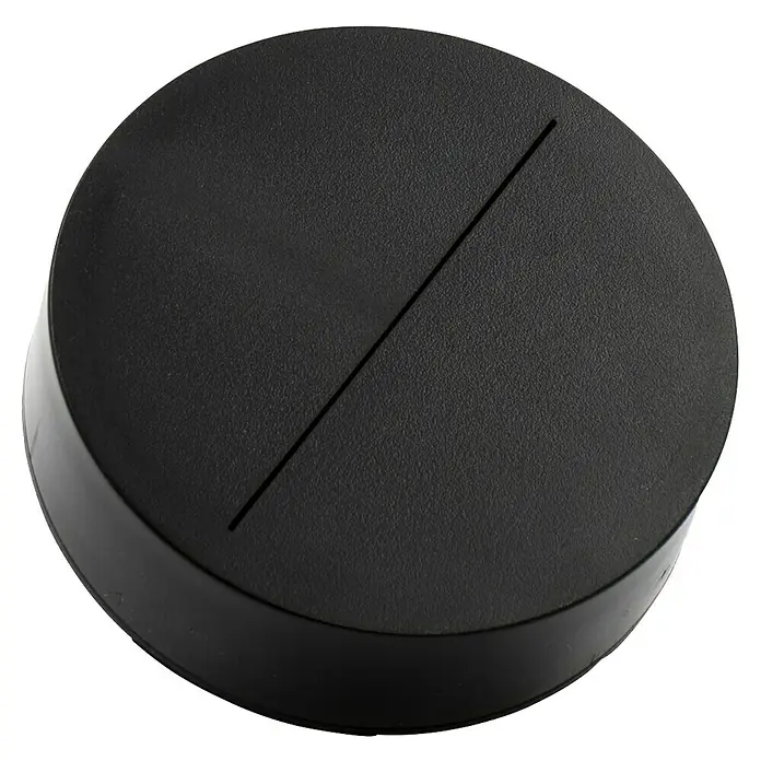 IO Minimal Aireador tipo ducha - Negro, Plástico, Cascada - Primer plano de una base redonda negra con una ranura, ideal para exhibir objetos y figuras pequeñas, su diseño simple acentúa el objeto presentado.