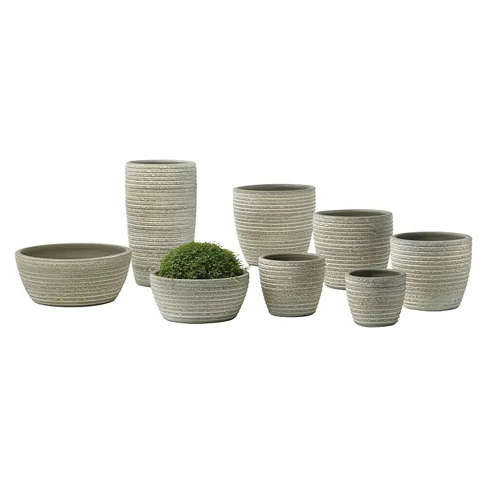 Soendgen Keramik Übertopf rund - Außenmaß (Ø x H): 19 x 17 cm, Creme, Keramik - Diese Aufnahme zeigt eine Vielzahl von gerillten Pflanzgefäßen aus Terrakotta in verschiedenen Größen und Formen, darunter ein Gefäß mit Grünbepflanzung.