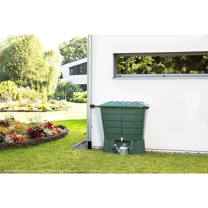 Garantia Basic Line Regentonnensockel - Passend für: Graf Regentonne 520 l, Grün, Grün - Grüne 520-Liter-Regentonne mit Unterstand und silberner Gießkanne in einem gepflegten Garten neben einem modernen Haus.