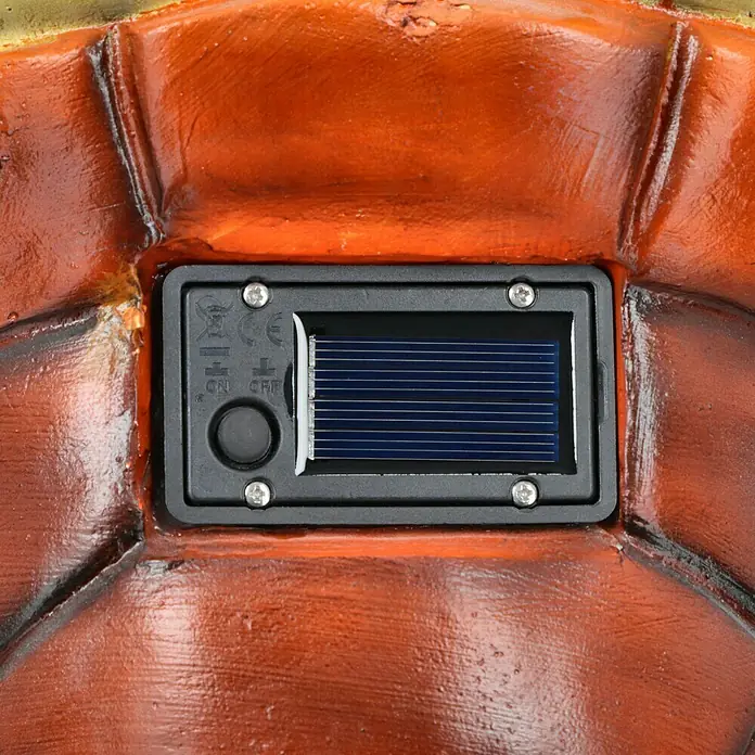 BAUHAUS Solar-Dekoleuchte - Lichtfarbe: Warmweiß, 24 x 27 x 35 cm, Schildkröte - Nahaufnahme eines Solarpanels an einer Gartenfigur, das Licht für eine stimmungsvolle Beleuchtung erzeugt.