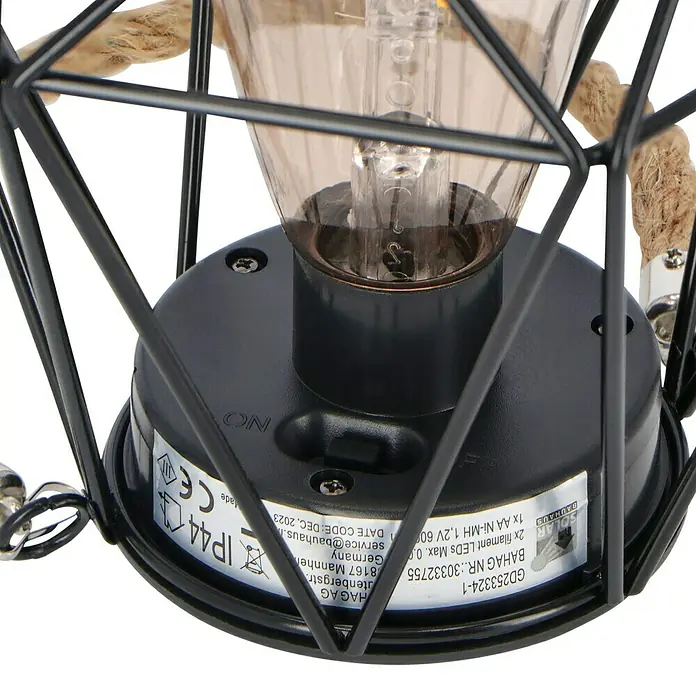 BAUHAUS Solar-Hängeleuchte - 0,03 W, L x B x H: 15 x 15 x 15,5 cm, Schwarz, IP44 - Nahaufnahme einer dekorativen Solarleuchte mit Glühbirne und Metallkäfig, ideal für den Außenbereich.