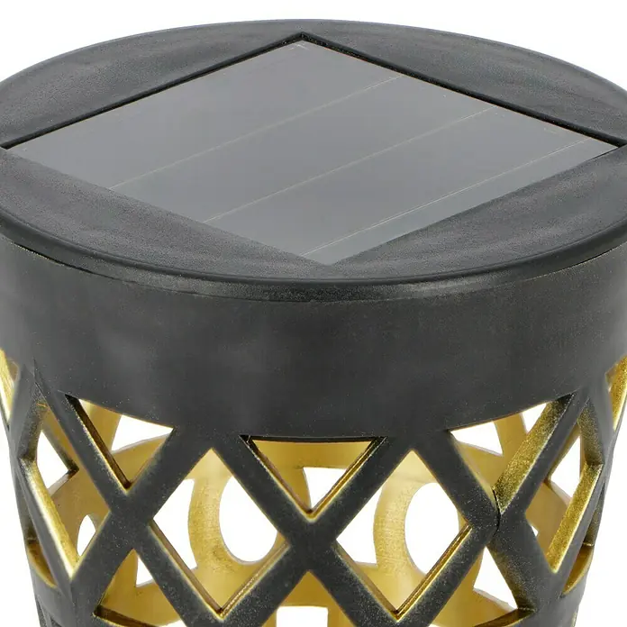 BAUHAUS Solar-Erdspieß - Schwarz/Gold, IP44, 3 lm - Nahaufnahme einer Solarleuchte mit geometrischem Muster, die eine Kombination aus schwarzem Metall und goldenen Akzenten aufweist.