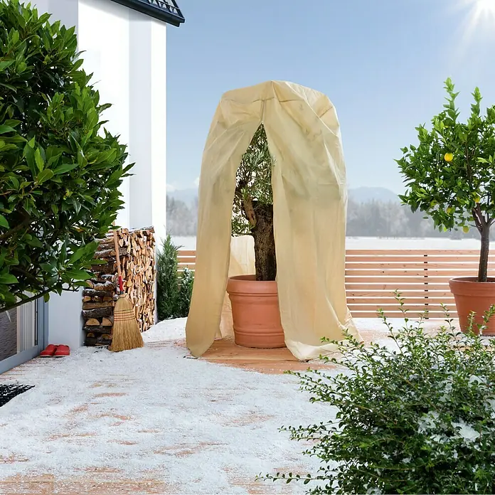 Winterschutzhaube - Ø x H: 1,25 x 2,4 m, Grammatur: 70 g/m² - Die Pflanzenschutzhaube schützt Pflanzen im Winter vor Frost und Schnee, während sie auf einer Holzterrasse neben anderen Pflanzen steht.