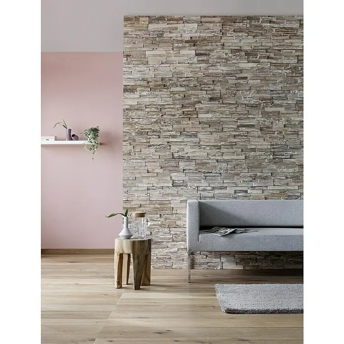 Wandpaneel Rustic White - Teak, 510 x 140 x 20 mm - Elegantes Wohnzimmer mit einer Akzentwand aus Naturstein, einem grauen Sofa und einem Holzhocker.
