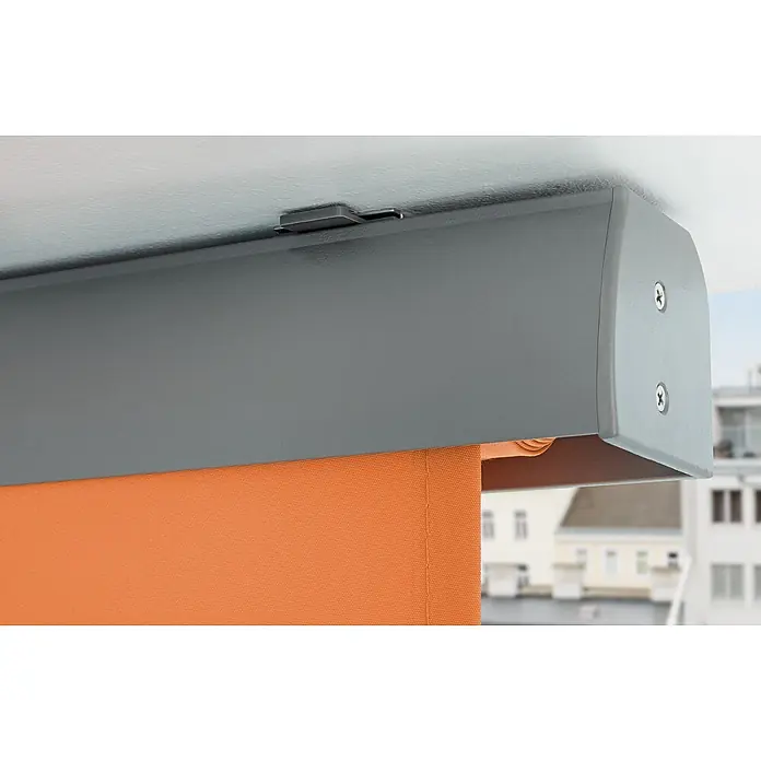 Sunfun Balkonverschattung - Orange, Breite: 1,4 m, Ausfall: 2,5 m - Nahaufnahme einer orangefarbenen Rollo mit einem grauen Gehäuse, das an einer Decke befestigt ist und Schrauben und einen Verriegelungsmechanismus aufweist.