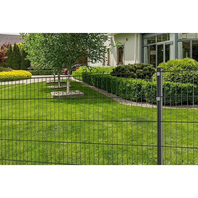 Peddy Shield Zaun-Set ESM - 10 x 1,2 m, Anthrazit, 11 -tlg. - Ein Gartenzaun aus Doppelstabmatten umgibt ein grünes Grundstück mit Bäumen und einem Haus im Hintergrund.