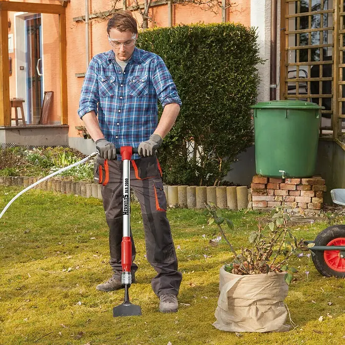 Herkules Multiherramienta neumática - 6,3 bar, Consumo de aire: 160 - 280 l/min - Un hombre usa un motocultor HERCULES DLS 2000 en el jardín, arando y cultivando la tierra.