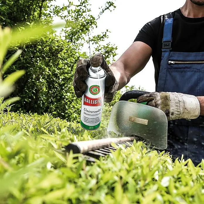 Ballistol Universalöl - 50 ml, Öl - Ein Gärtner, der eine Dose Ballistol Universalspray hält, während er eine Heckenschere benutzt.