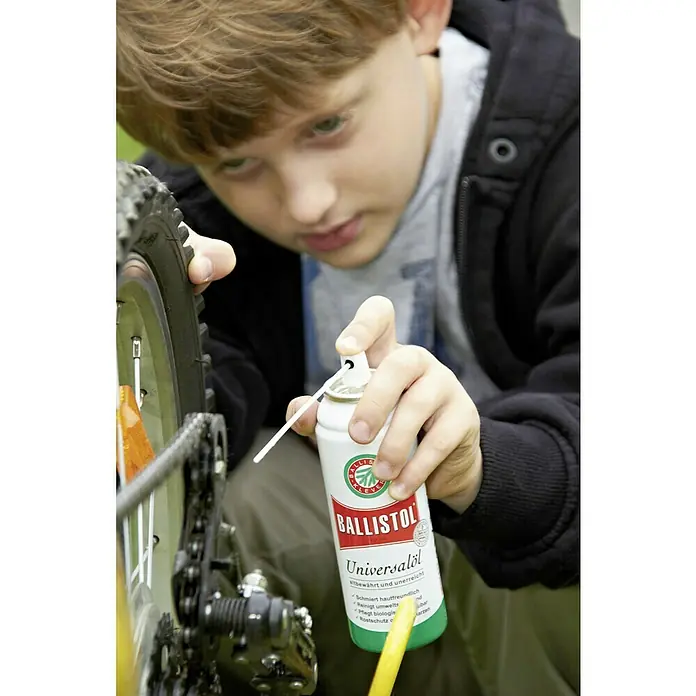 Ballistol Universalöl - 50 ml, Spray - Ein Jugendlicher wartet ein Fahrrad mit Ballistol Universalöl, das für seine vielseitigen Schmier- und Reinigungsfähigkeiten bekannt ist.