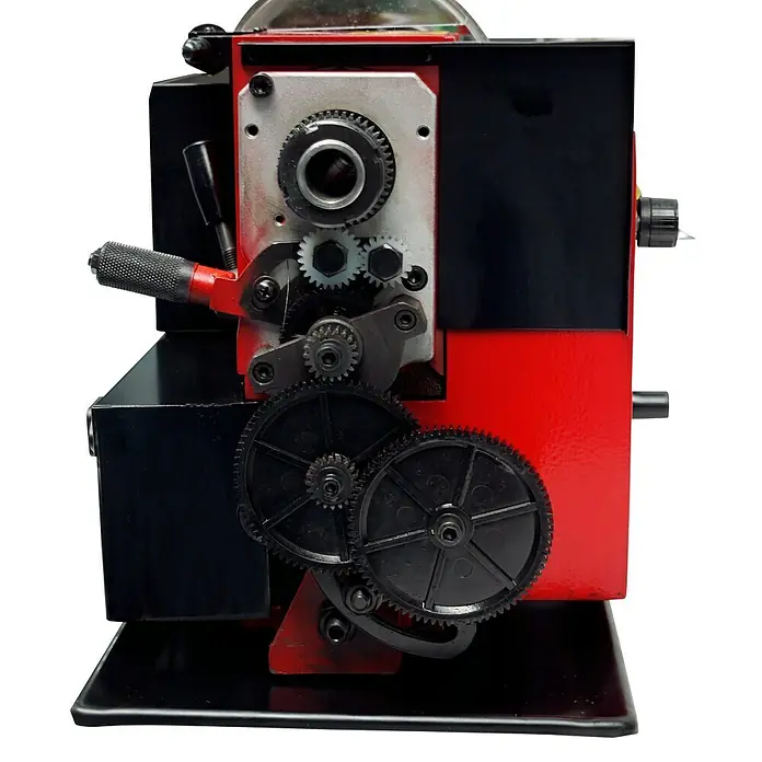 Rotwerk Drehmaschine EDM 350 DR - Leistung: 450 W, Max. Aufnahmehöhe: 74 mm, Spindelkonus: MK3 - Nahaufnahme einer rot-schwarzen Drehbank mit mehreren Zahnrädern, die das komplizierte Design und die Mechanik der Maschine hervorheben.