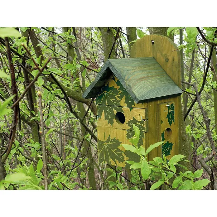 Dobar Nistkasten - 18,5 x 19 x 32 cm, Auswechselbare Einflugsöffnung - Ein dekoratives Vogelhaus mit Blättermuster in Grün- und Gelbtönen, montiert an einem Baum im Wald. Es bietet Vögeln einen sicheren Nistplatz.