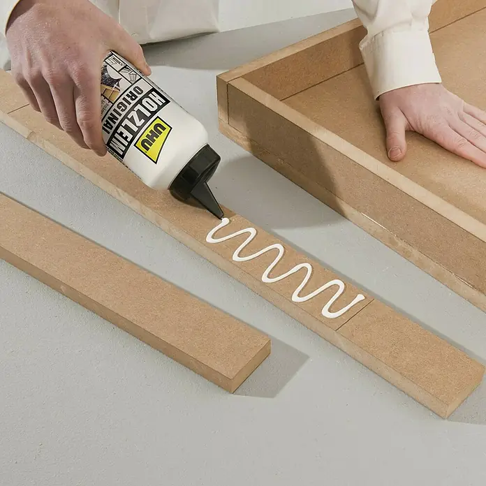 UHU Holzleim Original - 750 g, Lösemittelfrei - Nahaufnahme von UHU Holzleim Original beim Auftragen auf ein Holzstück, ideal für präzise Verklebungen im Handwerk.