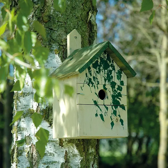 Dobar Nistkasten17,5 x 17 x 33 cm, Dekor: Camouflage - Ein hölzernes Vogelhaus mit grünem Dach und Blättermuster, das an einem Baum befestigt ist, bietet Vögeln ein charmantes Zuhause in der Natur.