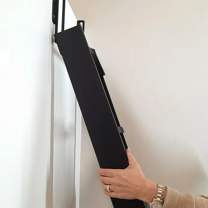Dolle Hochbettleiter - Holz, Schwarz, Anzahl Stufen: 10 Stk., Geschosshöhe: 237 cm - Eine Person montiert eine schwarze Wandgarderobe an einer weißen Wand. Die Garderobe ist platzsparend und funktional.