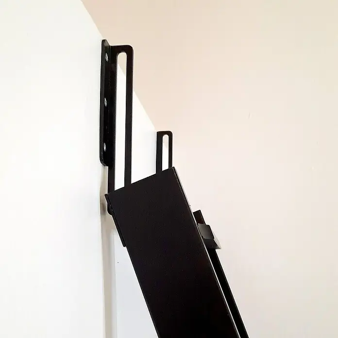 Dolle Hochbettleiter - Holz, Schwarz, Anzahl Stufen: 10 Stk., Geschosshöhe: 237 cm - Nahaufnahme einer schwarzen Wandhalterung, die an einer weißen Wand befestigt ist und ein schlankes, modernes Design mit Befestigungslöchern aufweist.