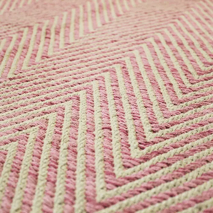 Kayoom Flachgewebeteppich Cocktail 500 - Pink, 230 x 160 cm, 100% Baumwolle - Nahaufnahme eines rosa-beigen Zickzack-Teppichs. Das Textildesign zeigt ein Muster aus gewebten Zickzacklinien in zarten Farbtönen.