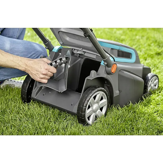 Gardena Elektro-Rasenmäher PowerMax 1800/42 - Leistung: 1.800 W, Schnittbreite: 42 cm - Ein Rasenmäher wird von einer Person auf einer grünen Rasenfläche bedient, wobei der Fokus auf dem Grasfangkorb liegt.
