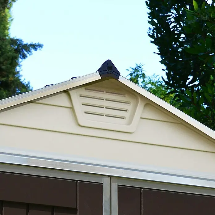 Palram – Canopia Gartenhaus Skylight 6x8 Tan - Außenmaß inkl. Dachüberstand (B x T): 185 x 229 cm, Kunststoff, Beige/Braun - Detailansicht des Giebels eines Gartenhauses mit Lüftungsschlitz und einem schwarzen Dachaufsatz, umgeben von Grün.