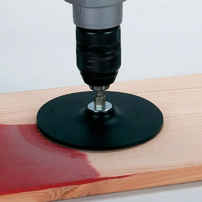 Wolfcraft Plato de lijado - Diámetro: 125 mm - Una herramienta de lijado con un disco de lijado negro redondo conectado a un taladro, trabajando sobre una tabla de madera.