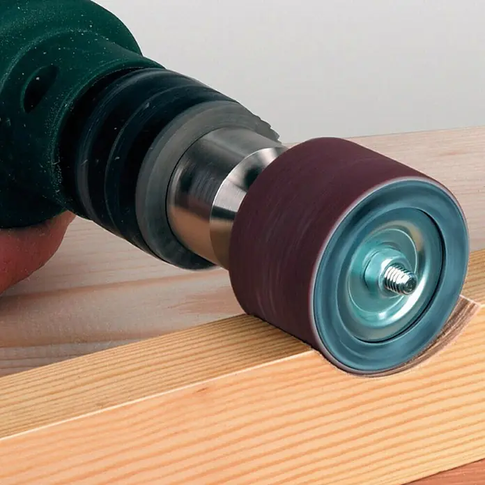 Wolfcraft Disco pulidor - Ø x Al: 45 x 30 mm - Primer plano de un accesorio de manguito de lijado en un taladro, trabajando en una pieza de madera. Perfecto para lijado de precisión.