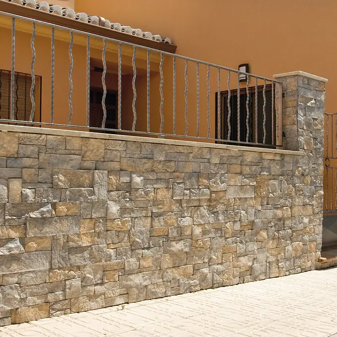 Revestimiento de piedra Alpes Pino - Cantidad total: 4 pzs. - Imagen de un muro de piedra con una barandilla de hierro decorativa, que muestra un atractivo detalle arquitectónico de la casa.