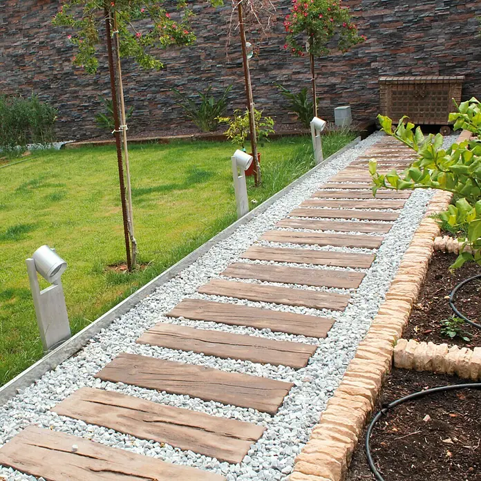 Traviesa de madera - 90 x 25 x 5 cm, Hormigón - Sendero de jardín con escalones de madera y grava, que conduce a través de un cuidado jardín con césped y parterres.