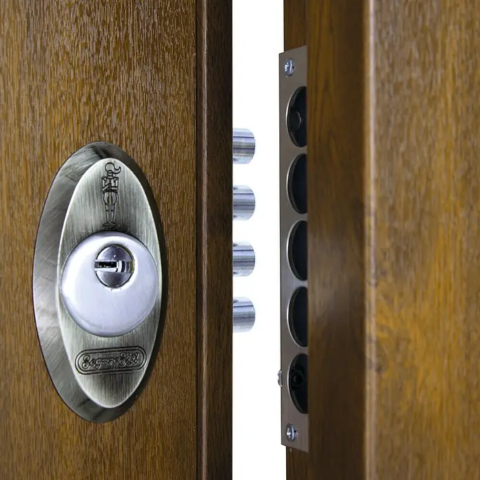 SegureStil Puerta de entrada exterior V500CC Serie V - 90 x 207 cm, Derecha, Nogal, Acorazada - Primer plano de una puerta de madera con una cerradura de seguridad plateada, mejorada con múltiples cerrojos que se enganchan al marco.
